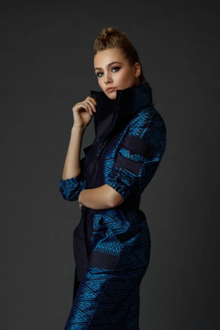 Model in relaxed pose wearing blue Thai silk couture jumpsuit with pleated collar, by Saskia ter Welle