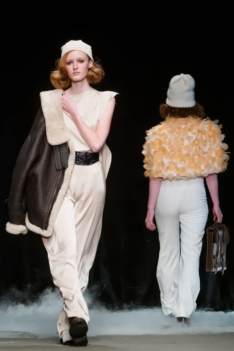 Two models on the catwalk, one wearing sand-coloured couture dresses by Saskia ter Welle at Amsterdam Fashion Wee