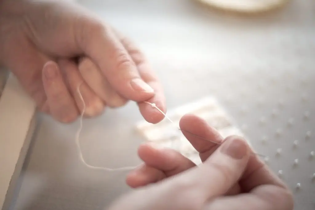 Close-up of hands working with beads in broderie d’art embroidery technique, by Saskia ter Welle