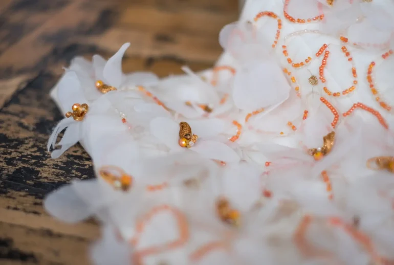 Close-up of couture bridal corset embroidered with orange beads and floral motifs, by Saskia ter Well