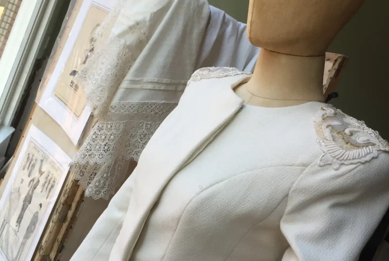 Off-white wool couture suit with embroidered epaulettes on a mannequin in the atelier of Saskia ter Welle in Doesburg